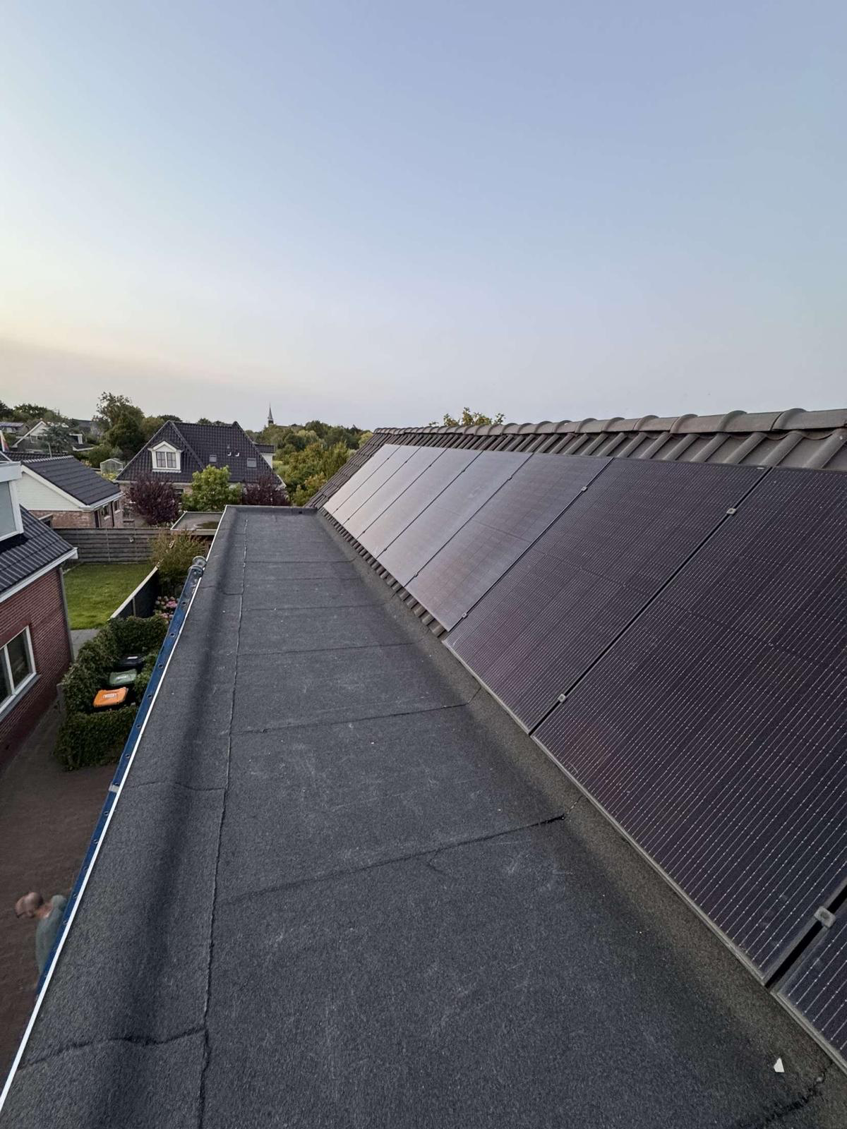 Overzicht van het vernieuwde platte dak in Leiden met zonnepanelen ernaast