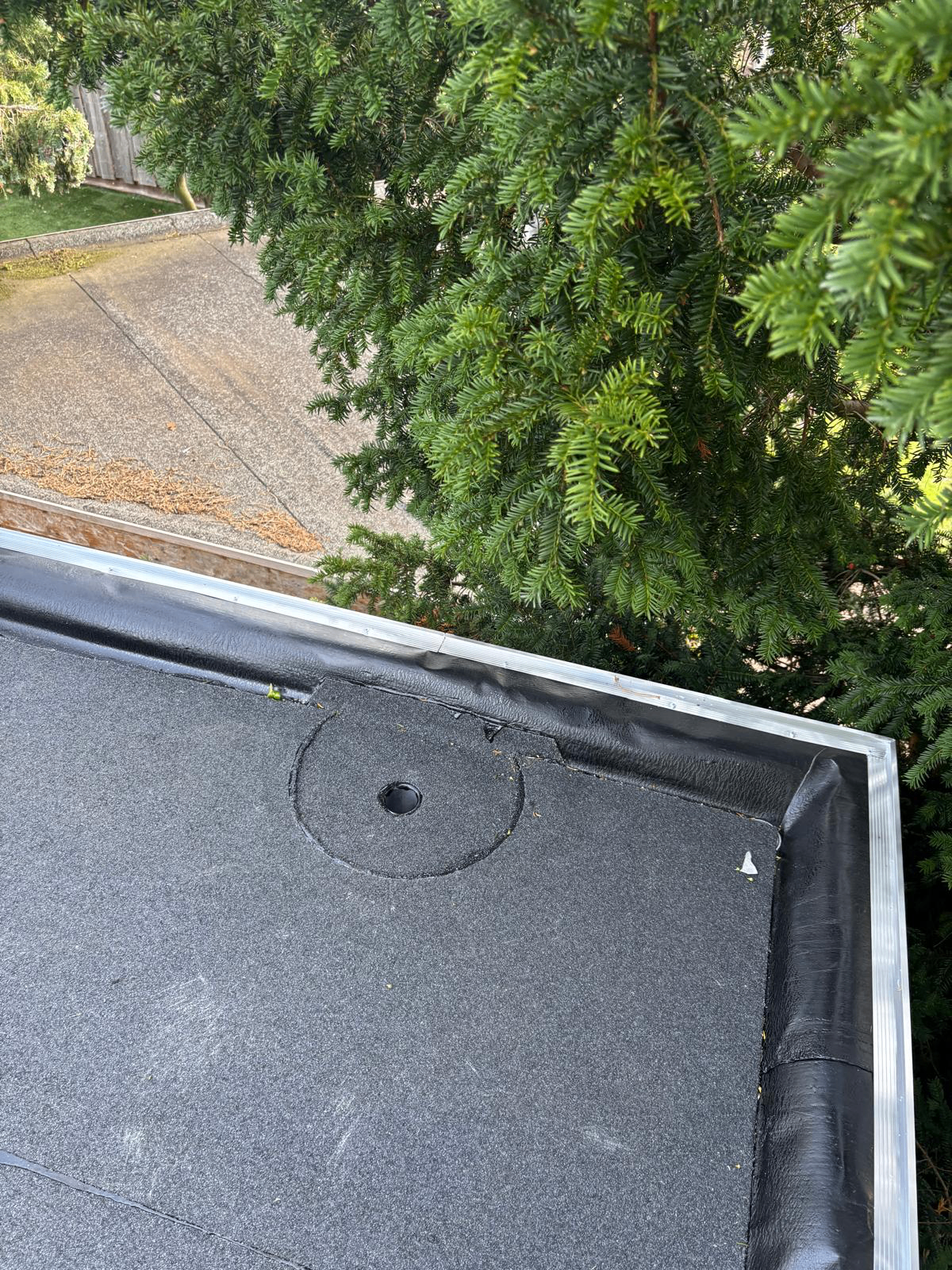 Detail dakrand met oude bitumen dakbedekking vóór renovatie
